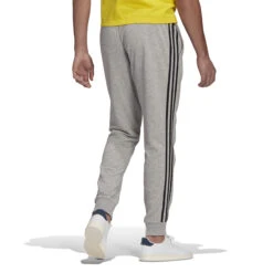 Adidas Essentials French Terry Tapered Cuff 3-Streifen Hose 10639898 13 Adidas Essentials French Terry Tapered Cuff 3-Streifen Hose 10639898 -Woehrl Populaire Boutique GK8889 4 APPAREL On Model Back View white